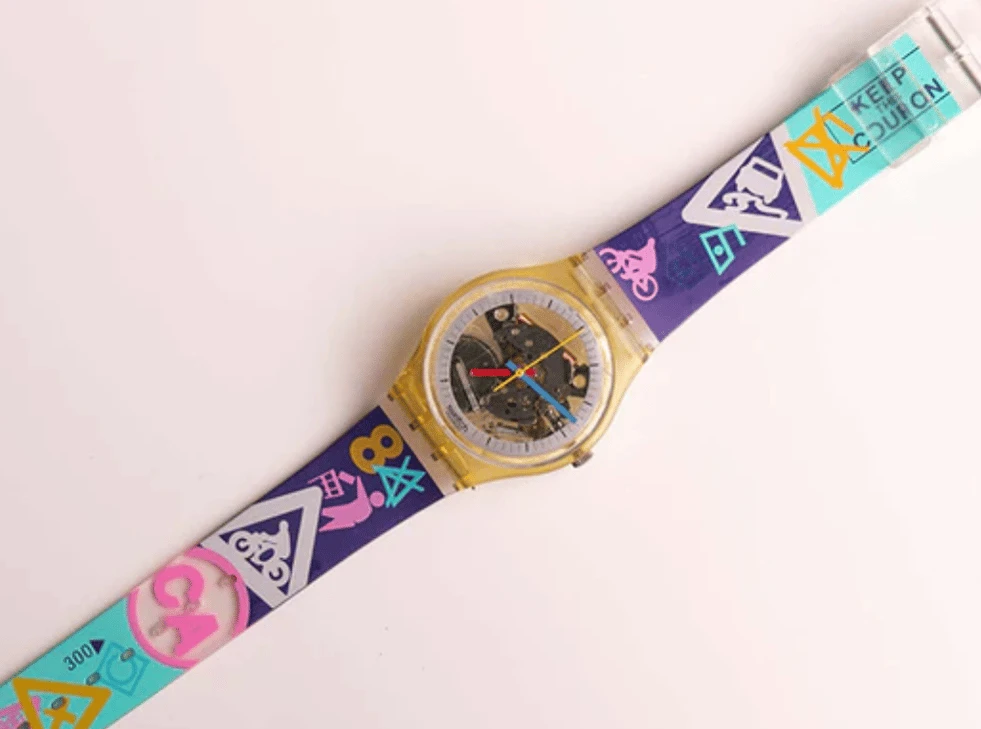 A 1980s Swatch Jellyfish watch with a skeleton dial and a neon-patterned strap.